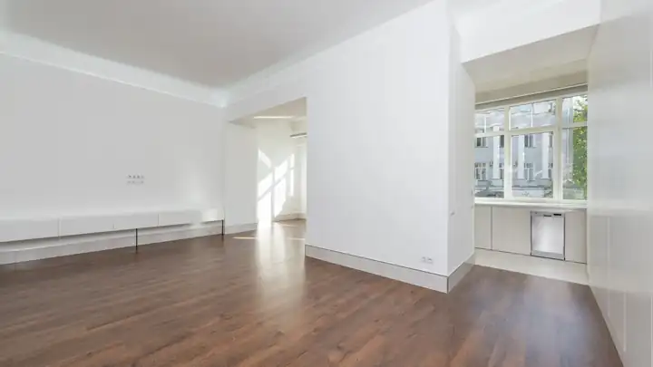 Pièce lumineuse rénovée avec parquet, comme une chambre aménagée sous les combles
