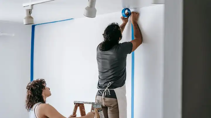 Peintres en bâtiment appliquant la peinture sur les murs d’un appartement