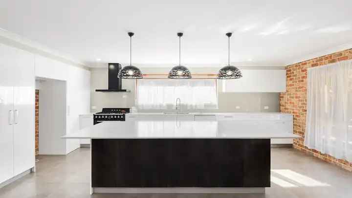 Cuisine rénovée avec îlot central et plan de travail clair