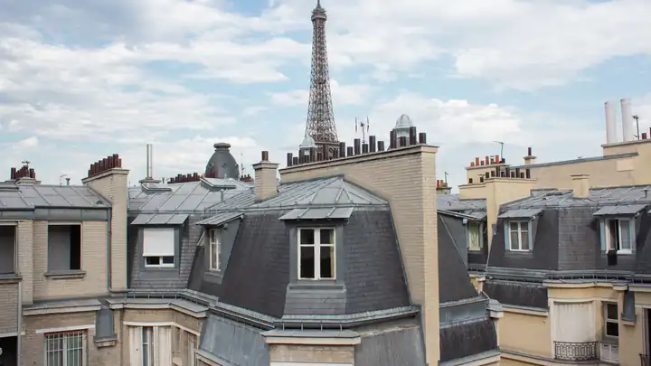Toits en zinc d’immeubles parisiens avec la tour Eiffel en arrière-plan