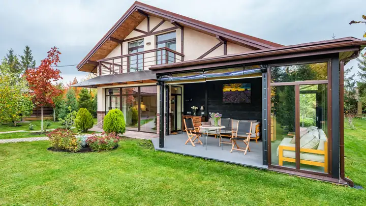Véranda moderne à toit plat ouverte sur le jardin d’une maison