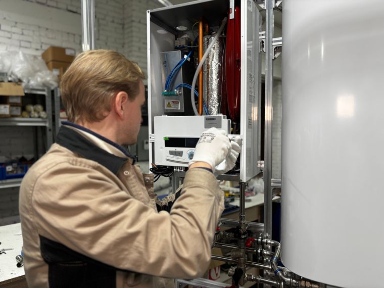 Chauffagiste ouvrant le capot d’une chaudière murale gaz pour un diagnostic